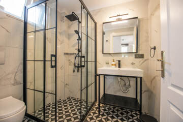 Modern bathroom with large shower, toilet and wash basin.